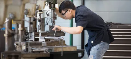 Mechanical engineering student working on a machine in the lab. 