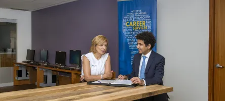 Two people talking at a table about Career Development.