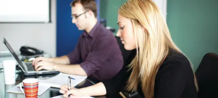 Business students working on a project in the workplace. 