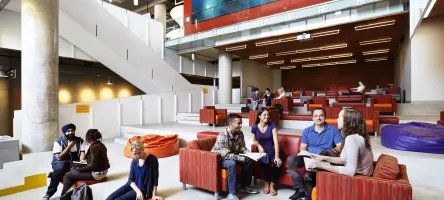 Students sitting in armchairs chatting at Waterfront campus