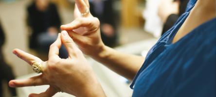Closeup of female student's hands as she uses American Sign Language.