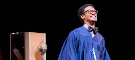 Male graduate next to ceremonial mace