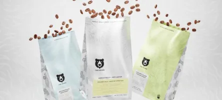 3 bags of coffee with beans coming out of the top