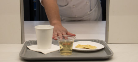 A technician slides a tray through a sensory tasting window