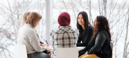 5 employees sitting at a table talking