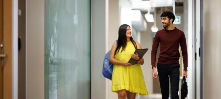 Two students walking down a hallway