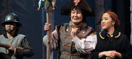 Three actors on stage dressed in period costume.