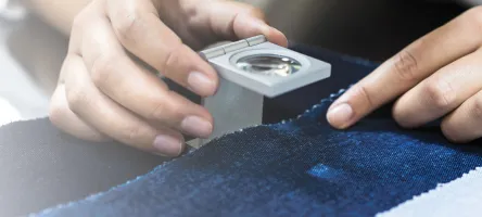 A woman examining the weave of a fabric sample