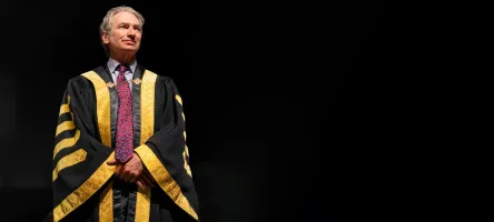 Chancellor Geoff Smith wearing robes at Convocation against a black background