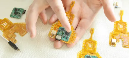 An open hand holds a small circuit board smart chip