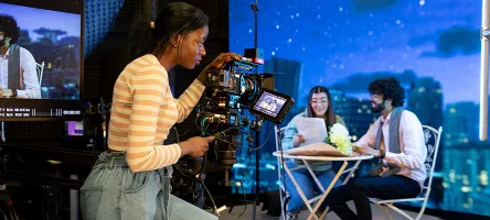a student filming a scene of two other students
