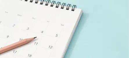 a pencil and a calendar on light blue background