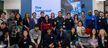 A large group of attendees pose together at the Alumni Industry Connection Series launch event, with a “Stay Connected!” George Brown Polytechnic Alumni Relations display in the background.