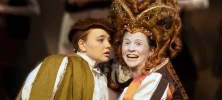 Two actors on stage dressed in period costume.