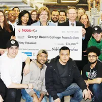 Students posing in front of an oversized cheque